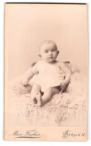 Fotografie Max Fischer, Berlin, Invalidenstr. 164, Portrait Kleinkind im weissen Kleid sitzend auf einem Fell