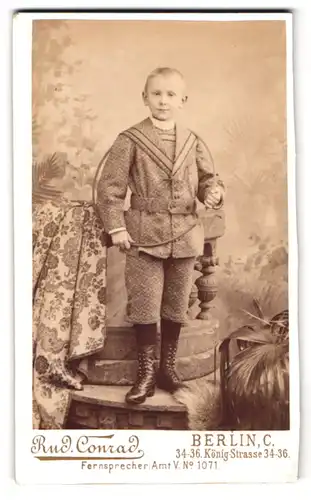 Fotografie Rud. Conrad, Berlin, König-Str. 34-36, Portrait junger Knabe im Stoff Anzug mit Reifen