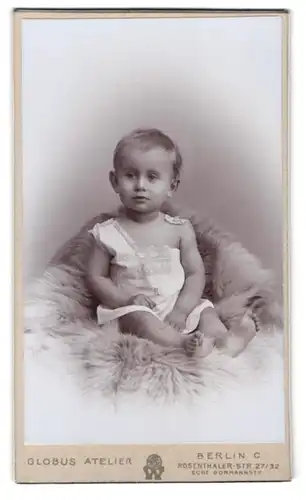 Fotografie Globus Atelier, Berlin, Rosenthaler-Str. 27 /32, Portrait kleiner Junge im weissen Kleid auf einem Fell