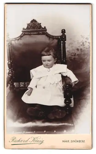 Fotografie Richard König, Mähr. Schönberg, Bahnhofstr. 631 /637, Portrait kleines Kind im Kleid sitzt im Stuhl