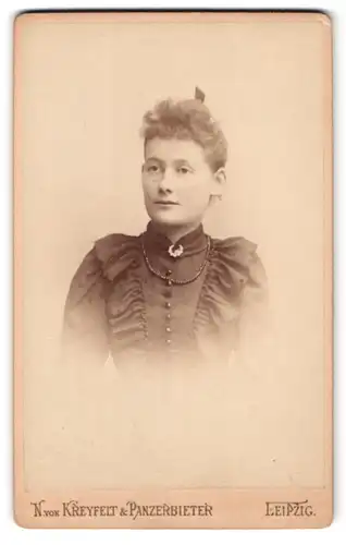 Fotografie N. von Kreyfelt & Panzerbieter, Leipzig, Löhrsplatz 2, Portrait junge Frau im Kleid mit Perlenkette, Locken