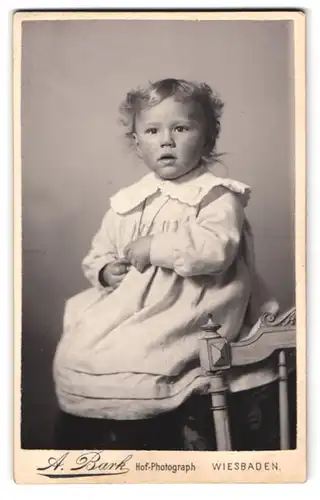 Fotografie A. Bark, Wiesbaden, Portrait kleines Mädchen im weissen Kleid mit Locken