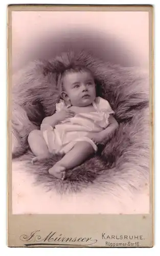 Fotografie J. Mürznseer, Karlsruhe, Rüppurrer-Str. 16, Portrait Kleinkind im weissen Leibchen auf einem Fell liegend