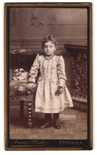 Fotografie Franz Becker, Ettlingen, Portrait kleines Mädchen im Kleid mit Perlenklette und Locken