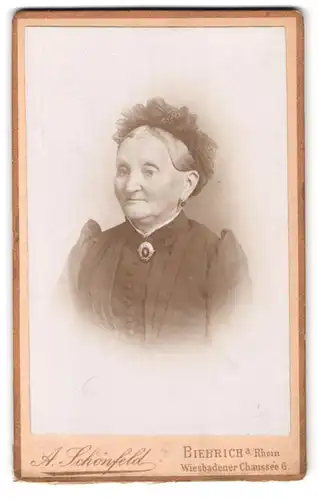 Fotografie A. Schönfeld, Biebrich a. Rh., Wiesbadener Chaussee 6, Portrait alte Frau im Biedermeierkleid mit Haube