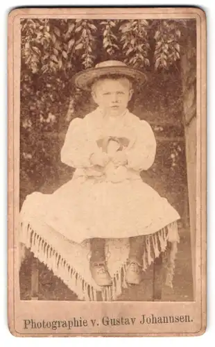 Fotografie Gustav Johannsen, Ort unbekannt, Portrait Kleinkind im Sommerkleid samt Hut