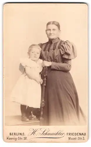 Fotografie H. Schmuckler, Berlin, Koenig-Str. 52, Portrait Mutter im Kleid mit Tochter im weissen Kleid posieren