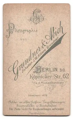 Fotografie Grundner & Abich, Berlin, Köpenickerstr. 62, Portrait Kleinkind im Leibchen auf einem Fell sitzend