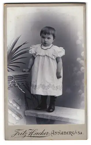 Fotografie Fritz Hacker, Annaberg i. Sa., Karlsplatz, Portrait kleines Mädchen im weissen Kleid mit Perlenkette