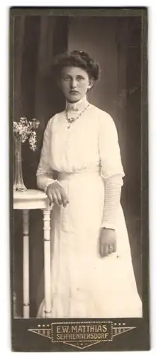 Fotografie E. W. Matthias, Seifhennersdorf, Portrait junge Sächsin im weissen Kleid mit Halskette schaut verträumt