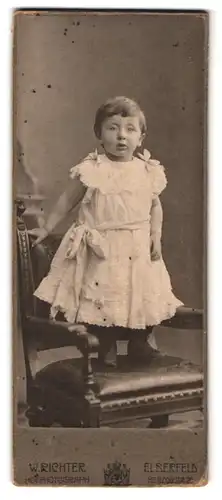 Fotografie W. Richter, Elberfeld, Herzogstr. 20, Portrait kleines Mädchen im weissen Kleid mit Schleifen