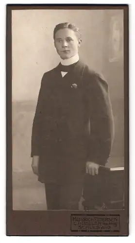 Fotografie Heinrich Petersen, Schleswig, Portrait junger Mann im Anzug mit Fliege und Seitenscheitel