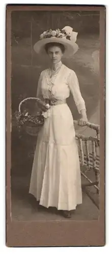 Fotografie Fotograf und Ort unbekannt, Portrait Dame im weissen Kleid mit Sommerhut und Blumenkorb