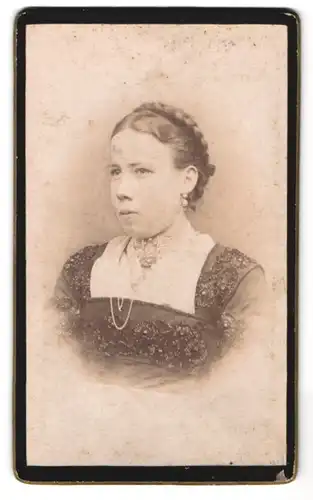 Fotografie Fotograf und Ort unbekannt, Portrait Dame im bestickten Kleid mit Brosche