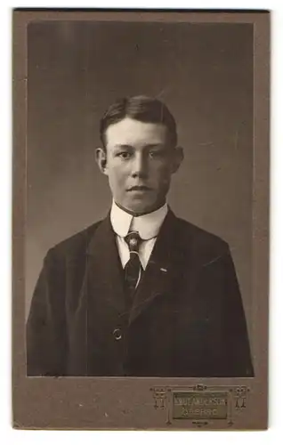 Fotografie Knut Anderson, Örebro, Ekersgatan 20, Portrait junger Knabe im Anzug mit Schlips und Segelohren
