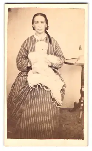 Fotografie Fotograf und Ort unbekannt, Portrait Mutter im gestreiften Kleid mit Kleinkind auf dem Schoss