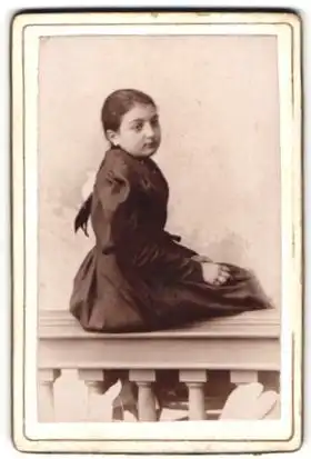 Fotografie Fotograf und Ort unbekannt, Portrait Mädchen im dunkeln Kleid schaut über die Schulter