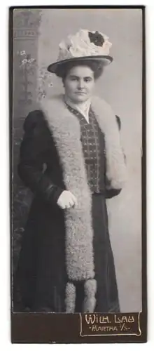 Fotografie Wilh. Lau, Hartha i. S., Portrait Dame im schwarzen Kleid mit Wollstola und Schleifenhut