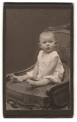 Fotografie Martin Herzfeld, Dresden, Pragerstr. 7, Portrait Kleinkind im weissen Leibchen mit Segelohren sitzt auf Sessel