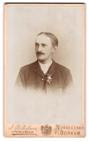 Fotografie Jean Baptiste Feilner, Borkum, Portrait Herr im karierten Anzug mit Ansteckblume und Moustache