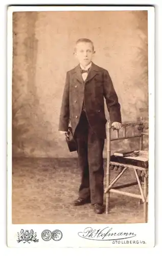 Fotografie Ph. Hofmann, Stollberg i. S., am Bahnhof, Portrait junger Knabe im Anzug mit Fliege und Hut im Atelier