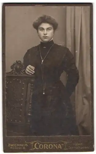 Fotografie Corona, Zwickau i. S., Münzstr. 8, Portrait junge Dame im schwarzen Kleid mit Halskette und toupierten Haaren