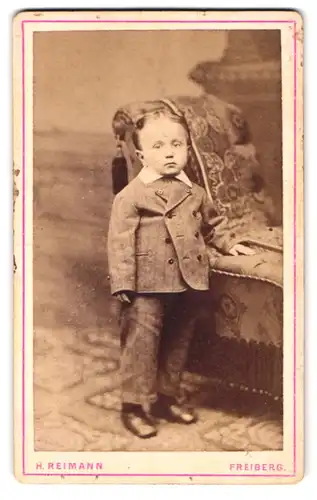 Fotografie H. Reimann, Freiberg, Weingasse 679, kleiner wie ein erwachsener Mann gekleideter Knabe