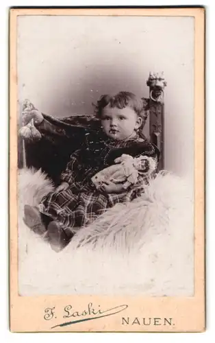 Fotografie J. Laski, Nauen, Dammstrasse 17, Portrait kleines Mädchen im karierten Kleid mit Puppe