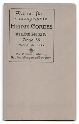 Fotografie Heinr. Cordes, Hildesheim, Zingel 36, Portrait Herr im Anzug mit Lederhandschuhen und Segelohren