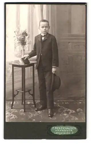 Fotografie F. Renziehausen, Hannover, Langelaube 2, Portrait kleiner Knabe im Anzug mit Hut vor einer Studiokulisse