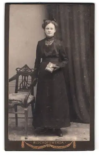 Fotografie Fotograf unbekannt, Bischofswerda, Portrait junge Dame im schwarzen Kleid mit Bibel und Haarschleife