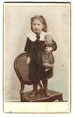 Fotografie Fotograf und Ort unbekannt, Portrait Mädchen im grünen Kleid mit Puppe in der Hand