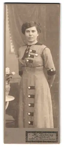 Fotografie H. Behning, Buxtehude, hübsche Frau im Kleid mit Locken in stehender Pose