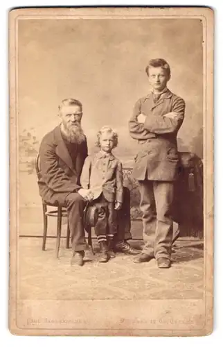 Fotografie Carl Jagerspacher, Gmunden, Portrait zwei charmante Herren und frecher blonder Bube in eleganten Anzügen