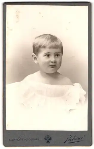 Fotografie C. Pietzner, Wien, Mariahilferstr. 3, Portrait blondes Kleinkind mit traurigem Blick im gerüschten Kleidchen