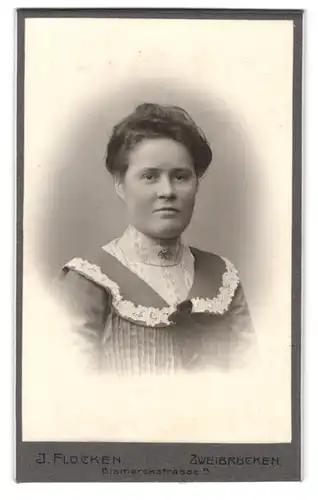 Fotografie J. Flocken, Zweibrücken, Bismarckstr. 9, Portrait einer elegant gekleideten Frau mit Stickerei am Kleid