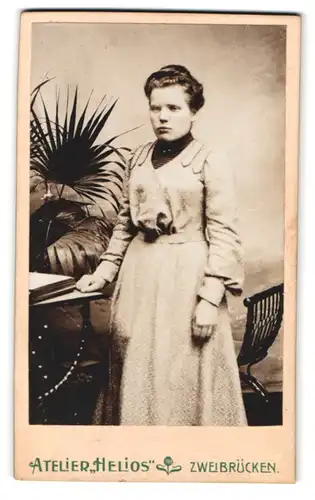 Fotografie Atelier Helios, Zweibrücken, Fruchtmarktstr. 16, Portrait dunkelhaariges Fräulein steht an einem Tisch