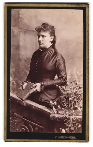 Fotografie v. Lobenwein, Villach, Südbahnstr., Portrait Dame im Biedermeierkleid mit Locken steht am Geländer