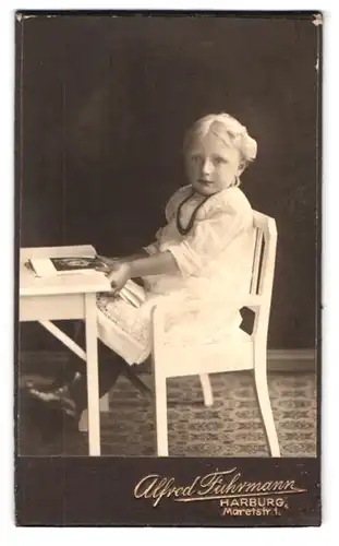 Fotografie Alfred Fuhrmann, Harburg, Maretstr. 1, Portrait blondes Mädchen im weissen Kleid sitzt am Tisch