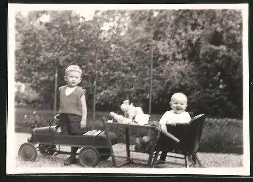 Fotografie Knabe mit Tretauto, glückliches Baby und Spielzeug