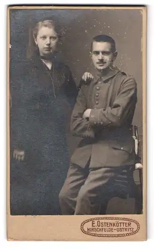 Fotografie E. Ostenkötter, Hirschfelde i. Sa., Bahnhofstr., Portrait Soldat in Feldgrau Uniform Rgt. 127 nebst Frau