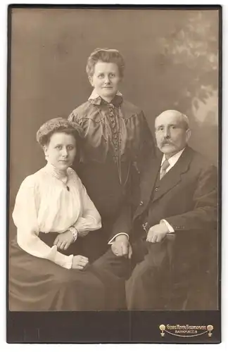Fotografie Georg Meyer, Braunschweig, Bankplatz 3, Portrait älteres Paar und junge Dame in zeitgenössischer Kleidung