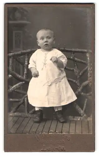 Fotografie Wilh. Schroers, Lehrte, Portrait süsses Kleinkind im weissen Kleid