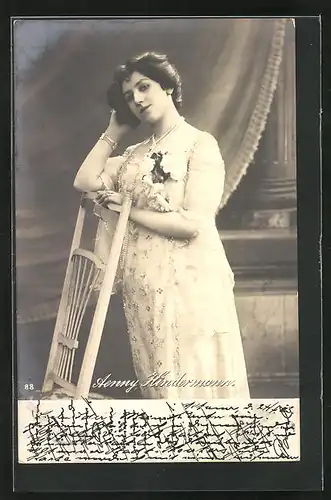 AK Schauspielerin Aenny Kindermann, in weissem Kleid an einem Stuhl