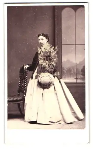 Fotografie Melliss, Liverpool, Portrait bildschönes Mädchen mit Hut im prachtvollen Kleid