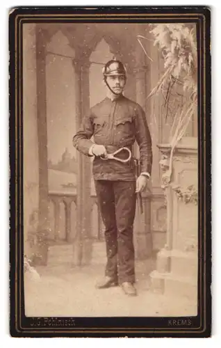 Fotografie J. G. Pohlnisch, Krems, Alleestrasse 18, Feuerwehrmann in Uniform mit Karabiner