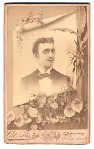 Fotografie Otto Faeht, Görlitz, Grüner Graben 29, junger Herr mit Zwicker nebst floraler Verzierung