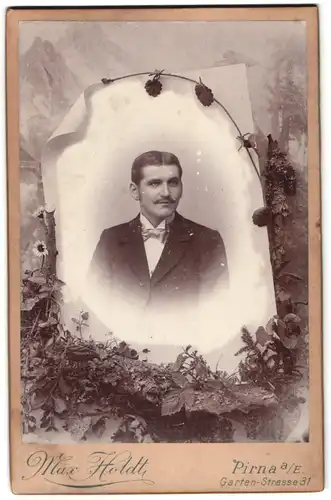 Fotografie Max Holdt, Pirna a. E., Gartenstr. 31, Passepartout-Portrait junger Herr im Anzug mit Studiokulisse