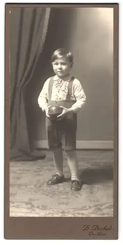 Fotografie Herm. Buchelt, Oerlikon, Querstr. 3, Portrait frecher kleiner Bube hält einen Ball in den Händen