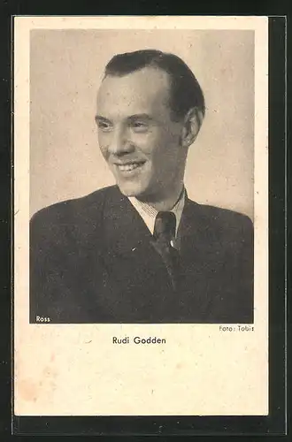 AK Schauspieler Rudi Godden im Anzug über seine Schulter lächelnd